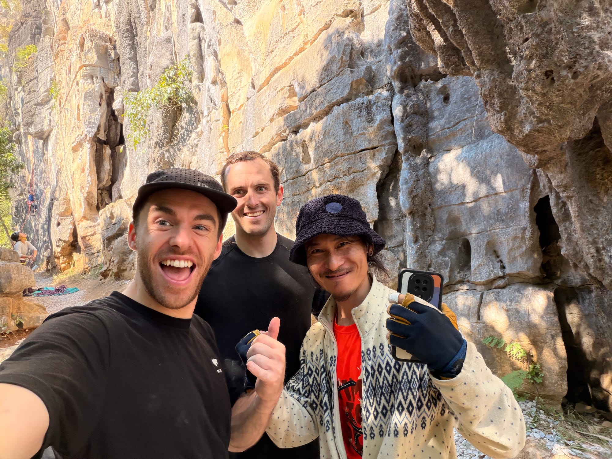 Trip photo: thumbs up with our climbing guide under the karst crag outside Yangshuo