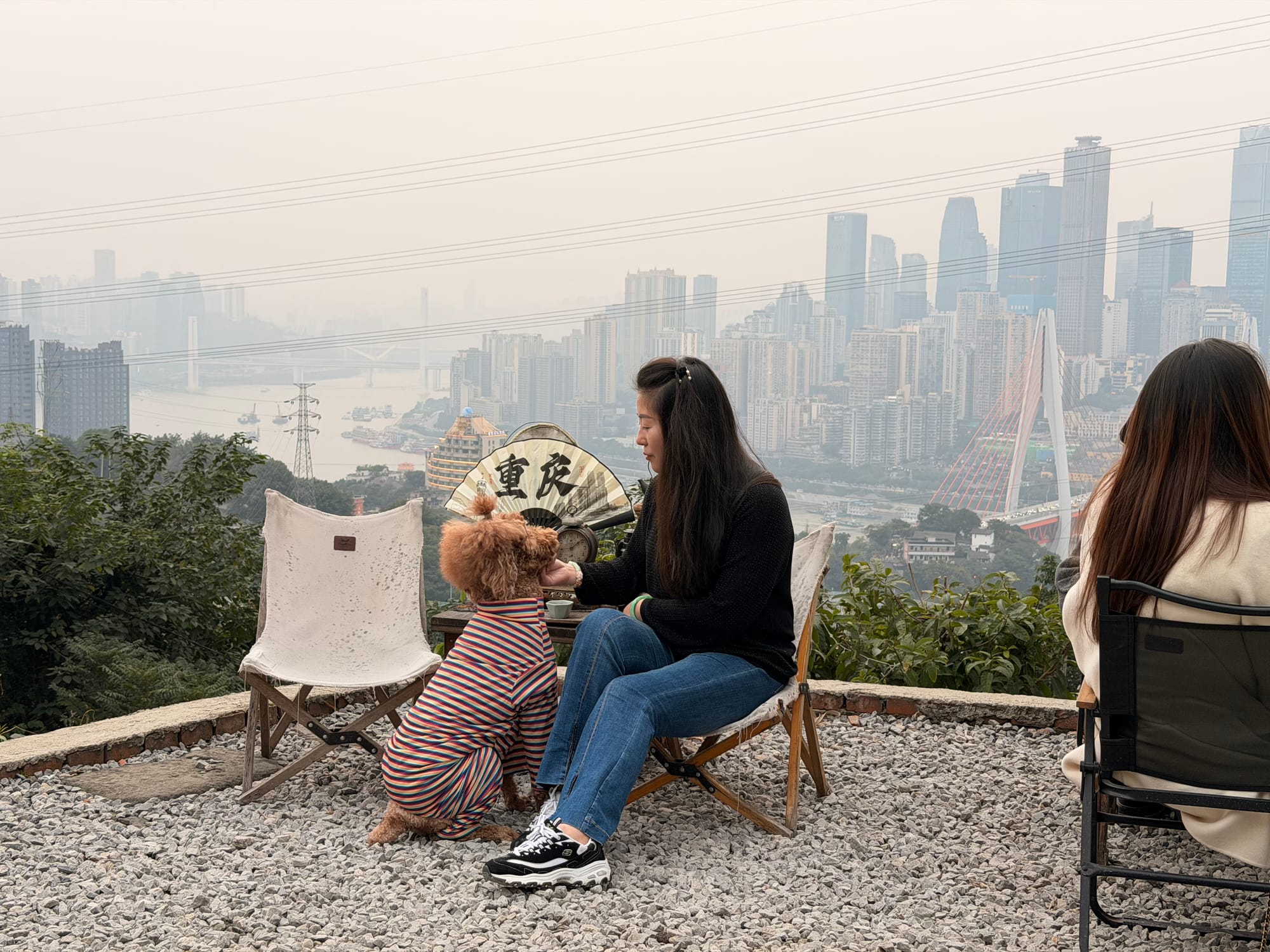 Trip photo: tea drinkers and a poodle on the hilltop viewpoint above the Chongqing skyline